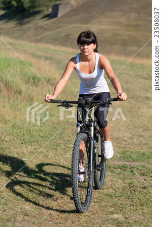 Young lady with bicycle on a spring meadow Young lady with bicycle on a spring meadow 23508037