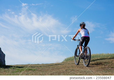 Young lady with bicycle on a spring meadow Young lady with bicycle on a spring meadow 23508047