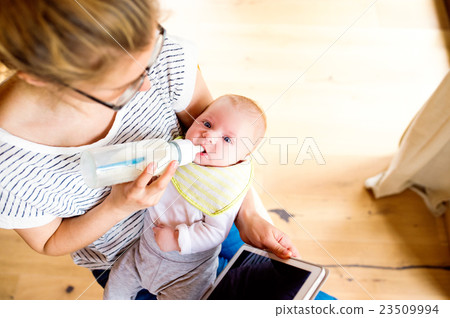 Unrecognizable mother holding baby son, milk in 23509994