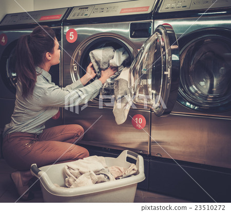 Beautiful woman doing laundry at laundromat shop. 23510272