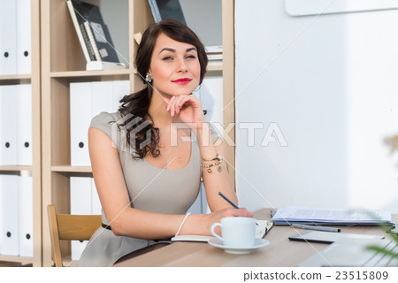 Beautiful female office worker sitting on 23515809