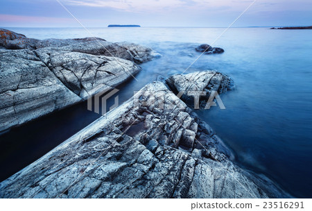 Stone beach stretching into the water 23516291