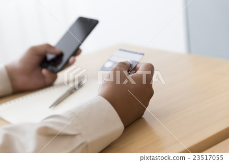 businessman's hand with mobile phone, credit card 23517055