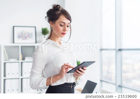 Young smiling female office worker at her Young smiling female office worker at her 23519600