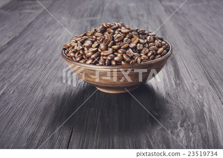 Coffee beans in bowl at wood background Coffee beans in bowl at wood background 23519734