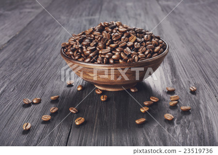 Coffee beans in bowl at wood background Coffee beans in bowl at wood background 23519736