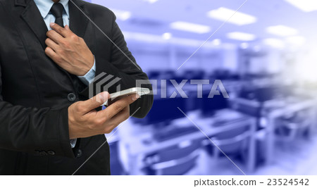 Businessman using the smart phone on Abstract blurred photo of empty computer room, education and business concept 23524542