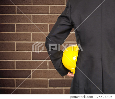 engineer in suit holding yellow helmet for workers security on granite wall background, industrial concept engineer in suit holding yellow helmet for workers security on granite wall background, industrial concept 23524806