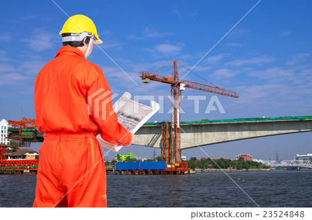 Portrait of Asian engineers looking at the blueprint on construction site worker over the river, industrial construction concept Portrait of Asian engineers looking at the blueprint on construction site worker over the river, industrial construction concept 23524848