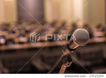Microphone over the Abstract blurred photo of conference hall or seminar room background 23525204