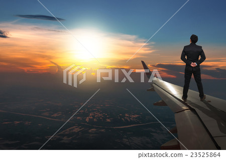 businessman standing looking the sunset on airplane wing, Challenge business concept 23525864