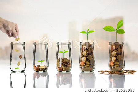 Hand putting Gold coins and seed in clear bottle on cityscape photo blurred cityscape background,Business investment growth concept Hand putting Gold coins and seed in clear bottle on cityscape photo blurred cityscape background,Business investment growth concept 23525933