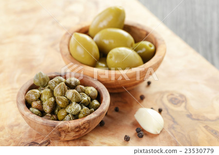green huge olives and capers on wood table 23530779