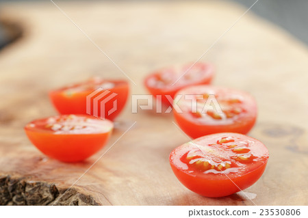 cut in half cherry tomatoes on wood table 23530806
