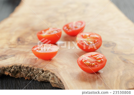 cut in half cherry tomatoes on wood table 23530808