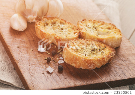 crostini with garlic and spices on wood table 23530861