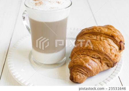 Croissant and glass of cafe latte on white plate Croissant and glass of cafe latte on white plate 23531646