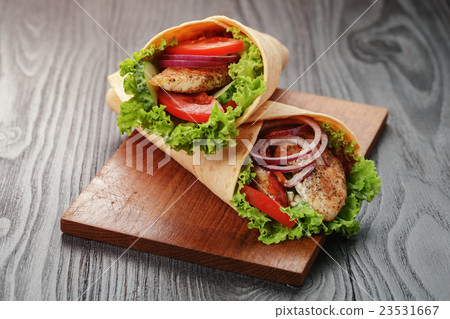 pair of fresh juicy tortilla wraps with chicken 23531667