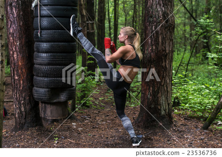 Woman practising kickboxing performing a leg axe 23536736