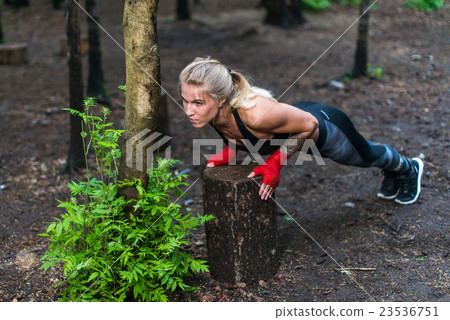 Muscular woman doing push-ups at park street work Muscular woman doing push-ups at park street work 23536751