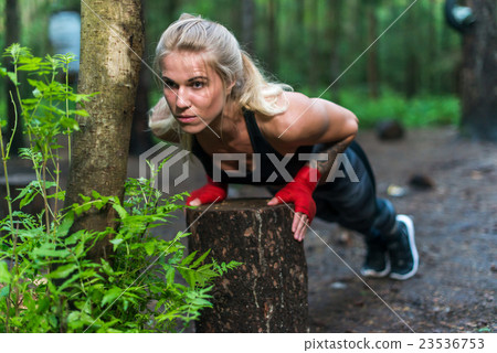 Muscular woman doing push-ups at park street work 23536753