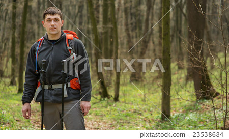 Man using hiking sticks poles outdoors in woods. 23538684