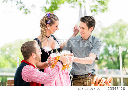 Friends in beergarden clinking glasses with beer 23542428