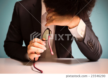 A male who removes eyeglasses and rubs his eyes A male who removes eyeglasses and rubs his eyes 23546290