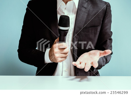 一個用麥克風說話的男人 23546299