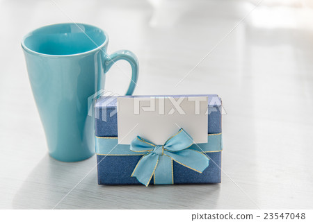 Blue gift box tea mug on gray wooden texture 23547048