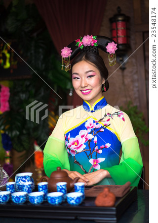 Young beautiful chinese woman with tea Young beautiful chinese woman with tea 23548174