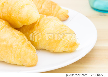 Croissant or Bread on Wood Table and Glass 23548770