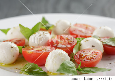 caprese salad with mini mozzarella balls 23551018
