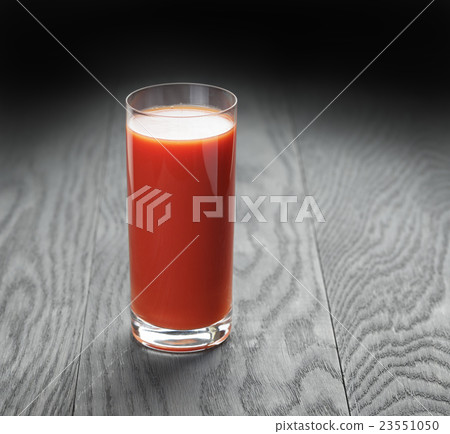 glass of tomato juice on wooden table 23551050