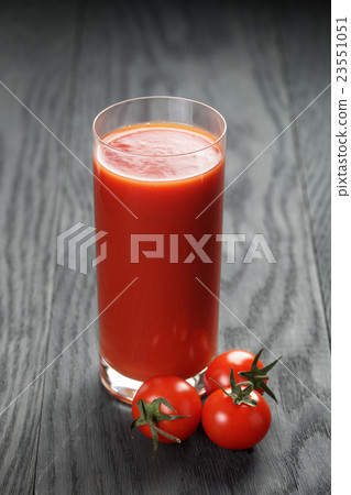 glass of tomato juice on wooden table glass of tomato juice on wooden table 23551051