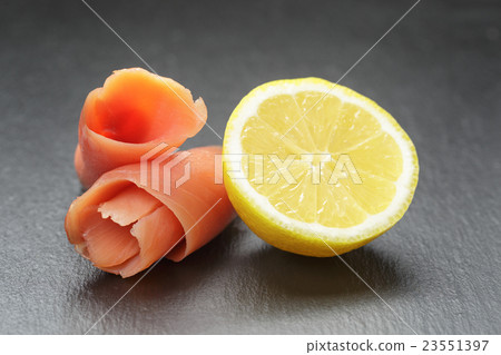 rolls of sliced smoked salmon on slate board 23551397