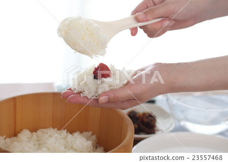 A woman holding a rice ball 23557468