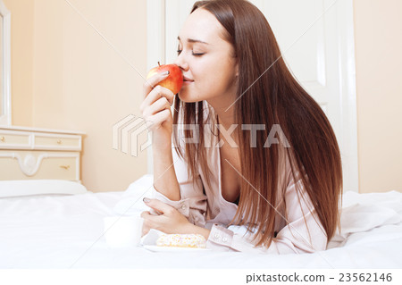 young pretty brunette woman laying in bed, luxury 23562146