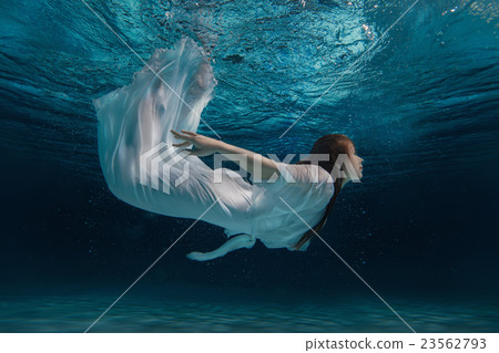 Woman in a white dress under water. Woman in a white dress under water. 23562793