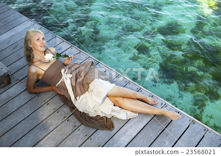 beautiful woman in a long dress on a wooden platfo beautiful woman in a long dress on a wooden platfo 23568021