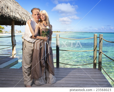 man gives a rose to the woman on the turquoise sea man gives a rose to the woman on the turquoise sea 23568023