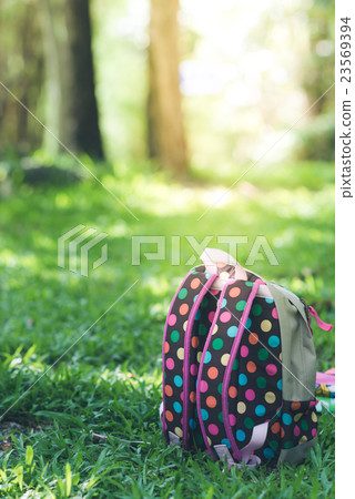 Colourful backpack standing on green grass Colourful backpack standing on green grass 23569394