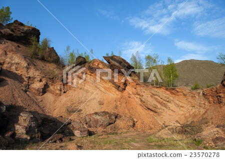 Waste heaps of red rock in industrial district 23570278