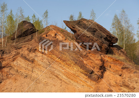 Waste heaps of red rock in industrial district 23570280