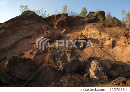 Waste heaps of red rock in industrial district 23570284