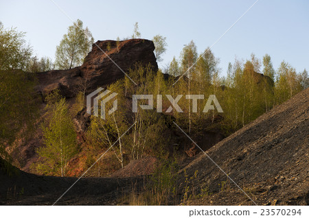 Waste heaps of red rock in industrial district 23570294