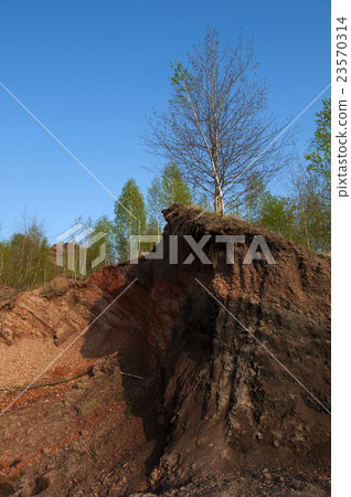 Waste heaps of red rock in industrial district 23570314