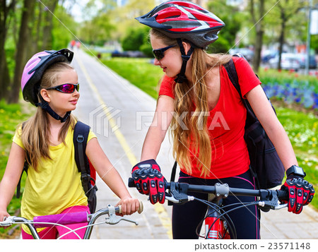 Girls children cycling on yellow bike lane. 23571148
