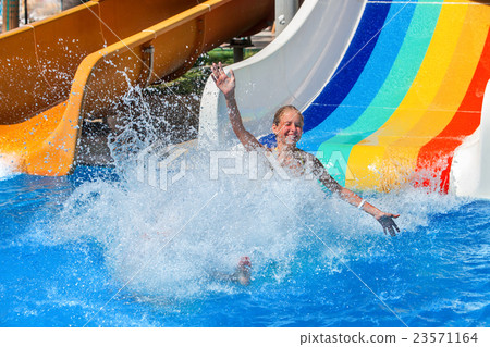 Child on water slide at aquapark show thumb up. 23571164