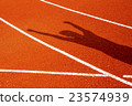 The shadow of man on red running track 23574939